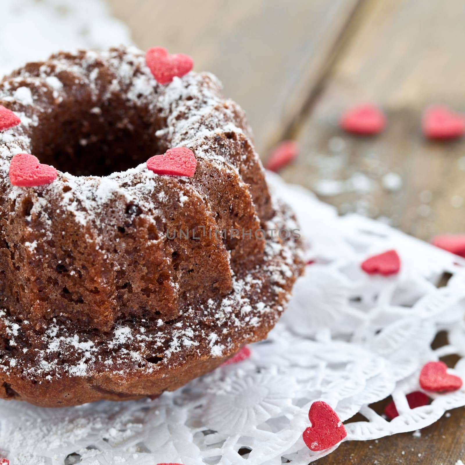 Small Gugelhupf with pink sugar hearts and icing sugar