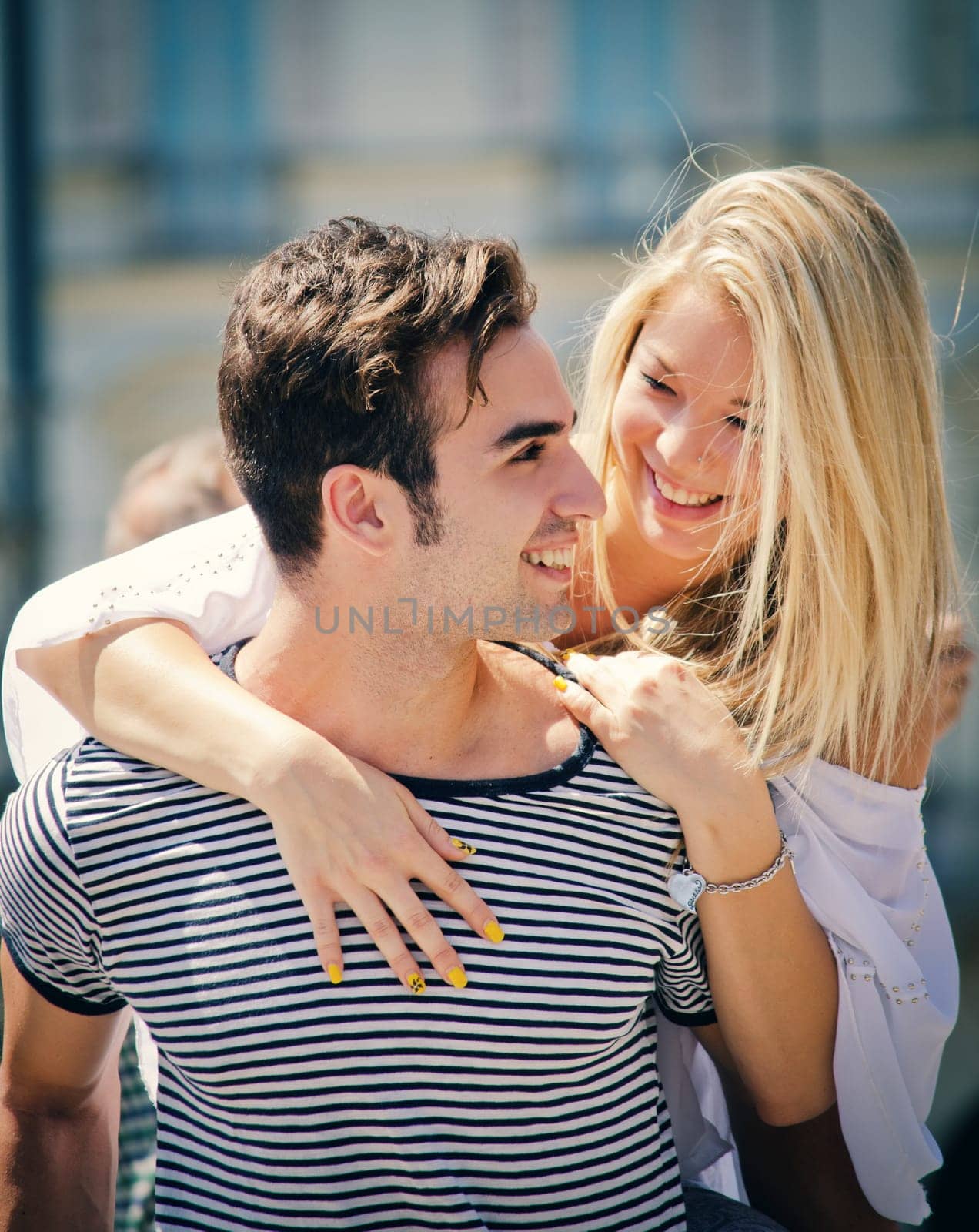 Romantic couple looking at each other smiling and having fun outdoors