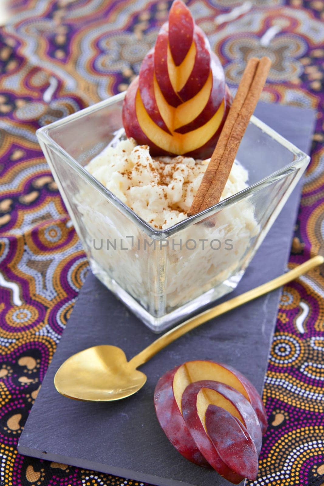 rice pudding in small bowls with cinnamon and fresh plums
