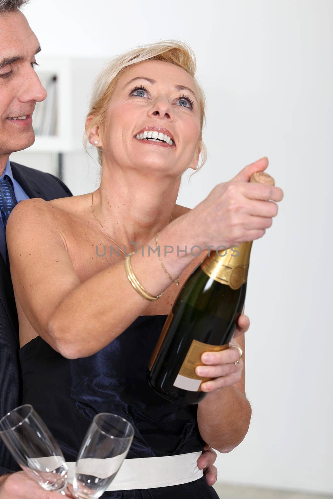couple opening a bottle of champagne