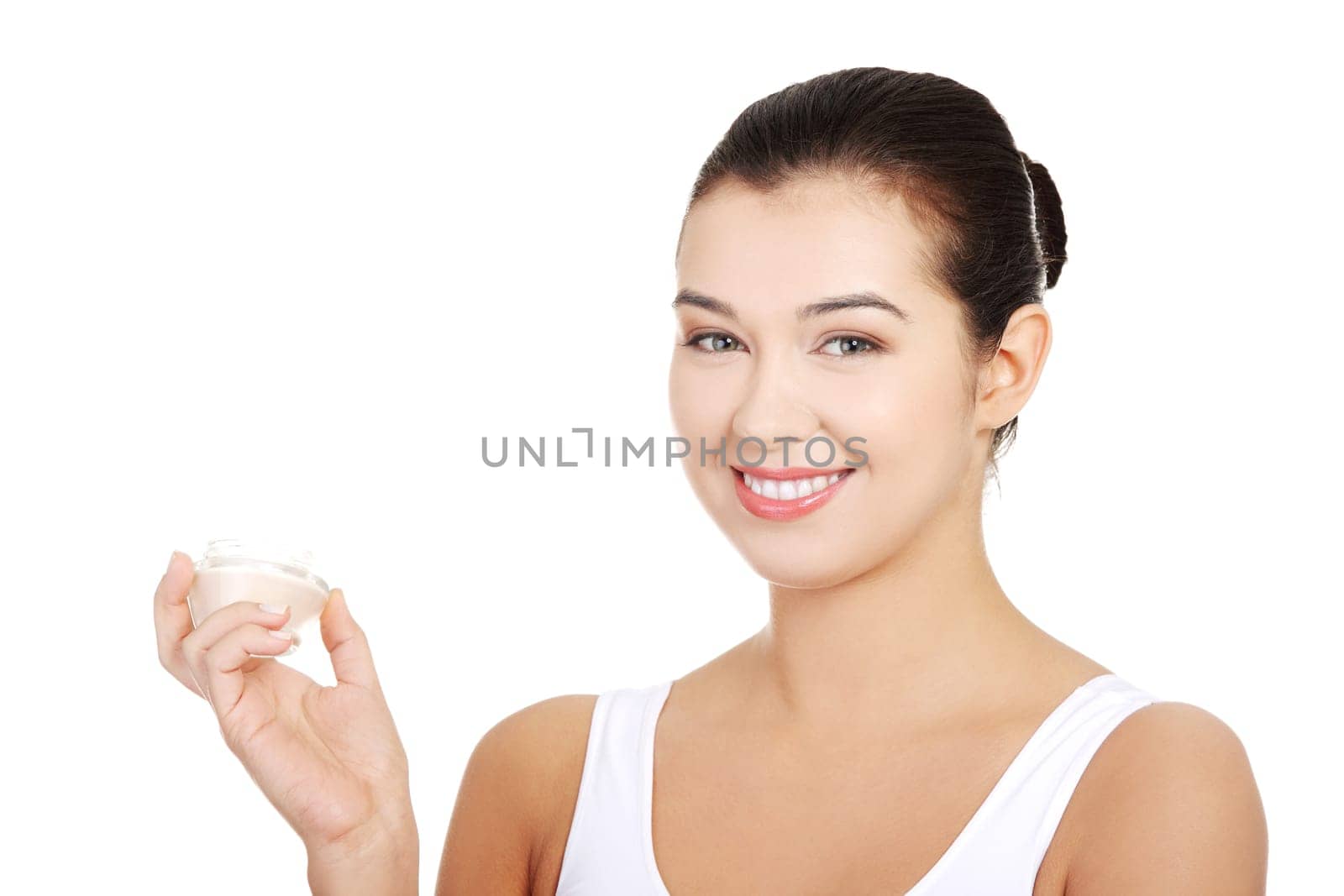 Woman applying lifting cream from container on face, isolated on white