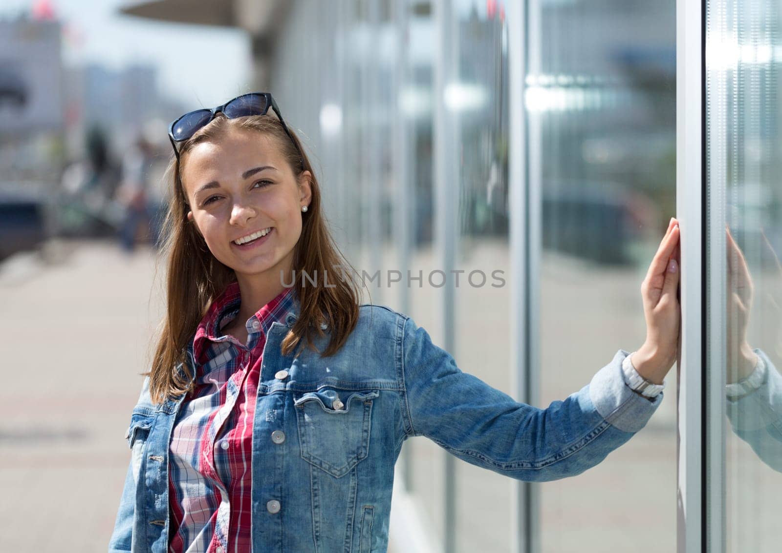 Young beautiful stylish girl on the street next to the shop windows
