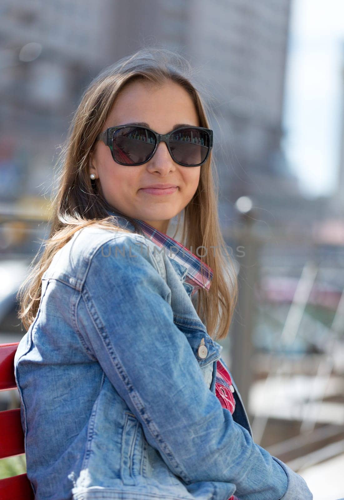 Young beautiful stylish girl smiling on a sunny day on the street