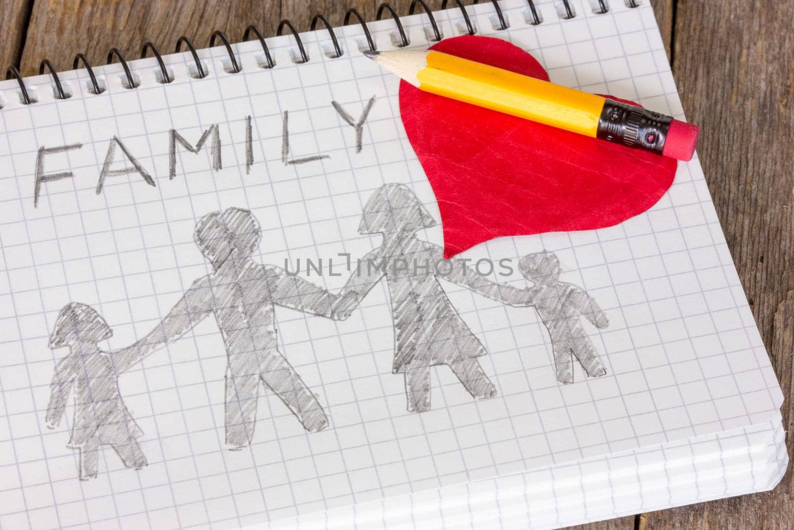 Pencil and heart on the notebook with  drawing of family