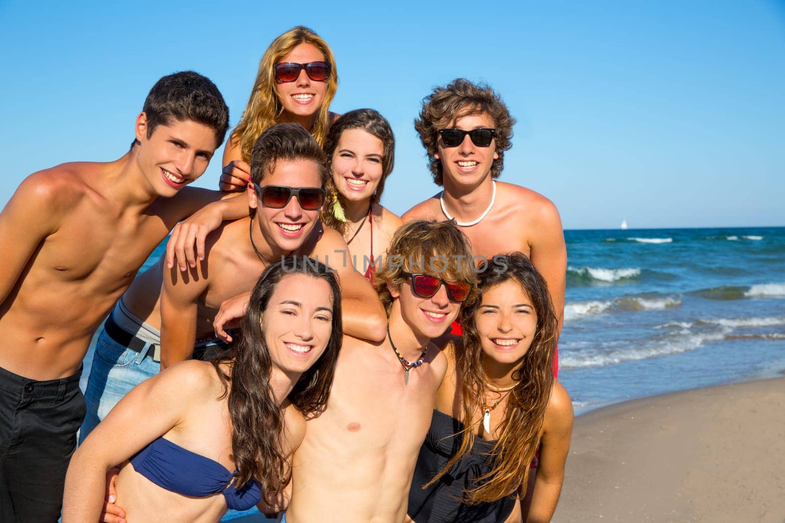 Happy teenagers young group together on beach in summer vacations