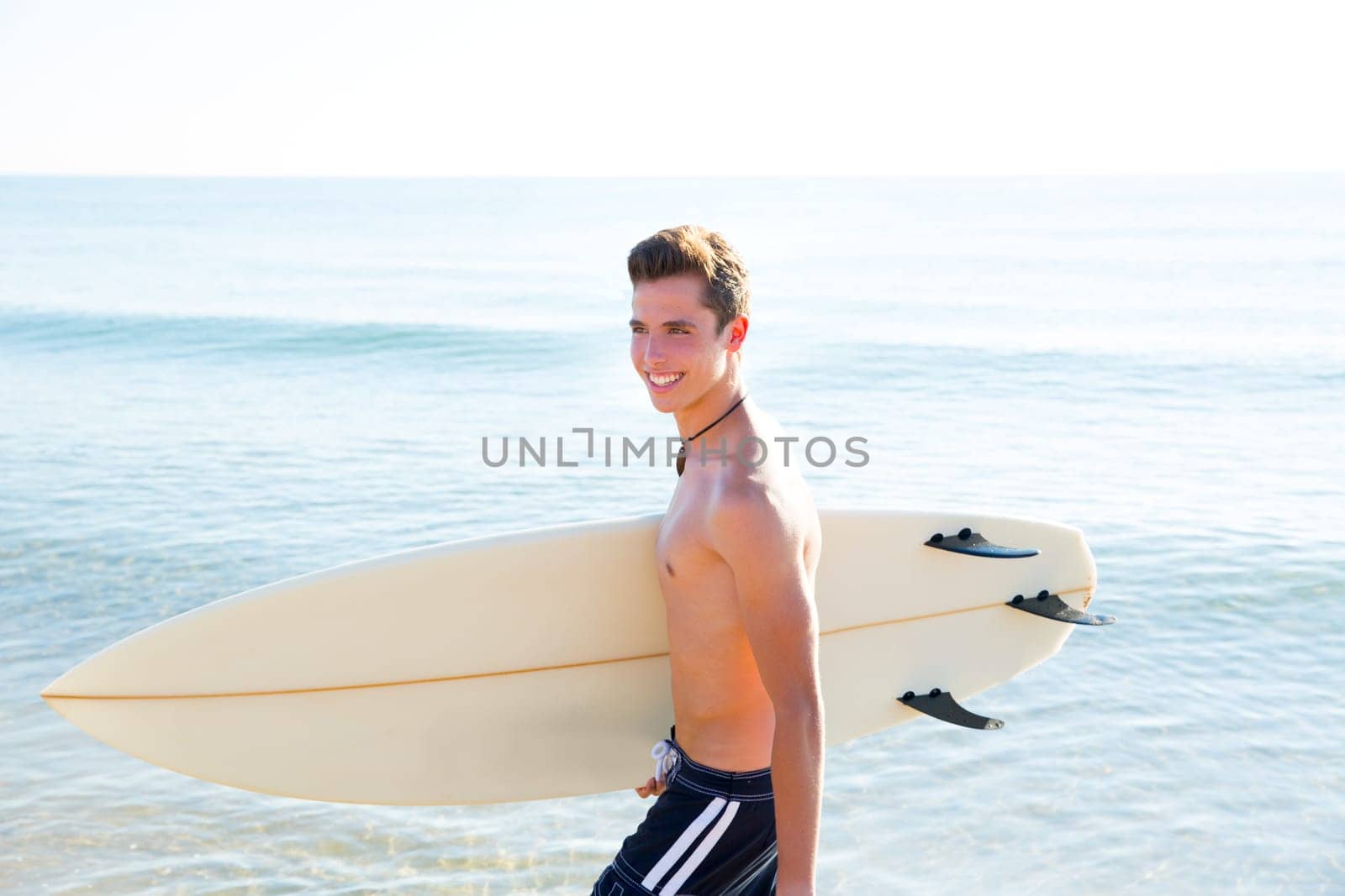 Surfer handsome boy teenager with surfboard in beach shore