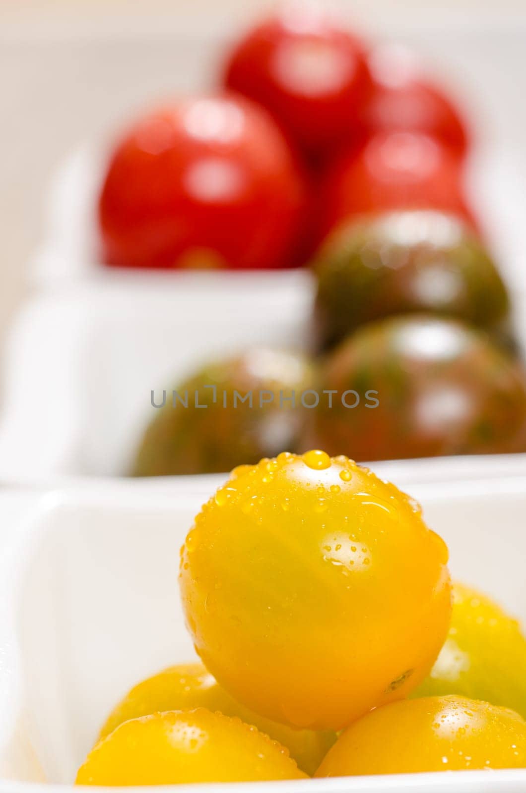 Close-up yellow wet tomato in portrait format