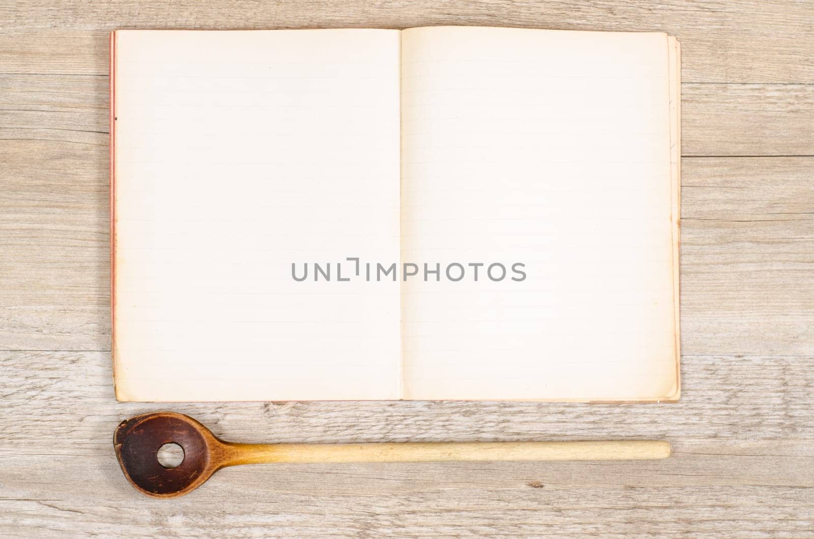 Old paper from a book with wooden spoon and text space for advertising space