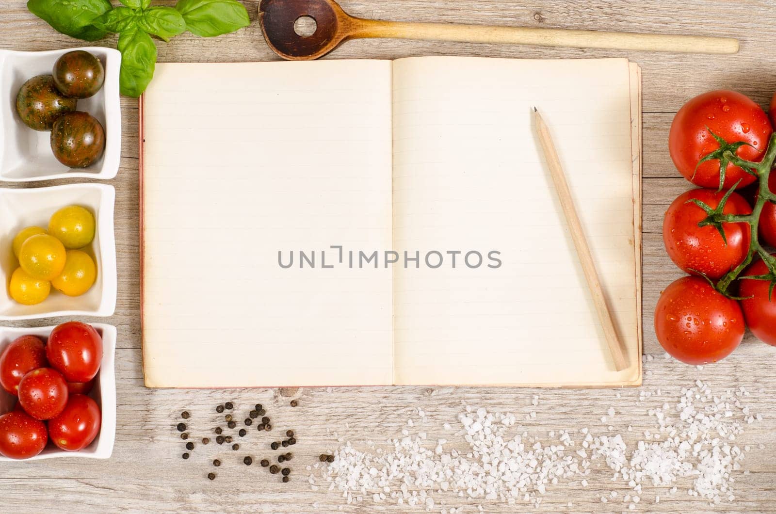 Old book with advertising space with pencil,cooking spoon,pepper,salt and tomatoes
