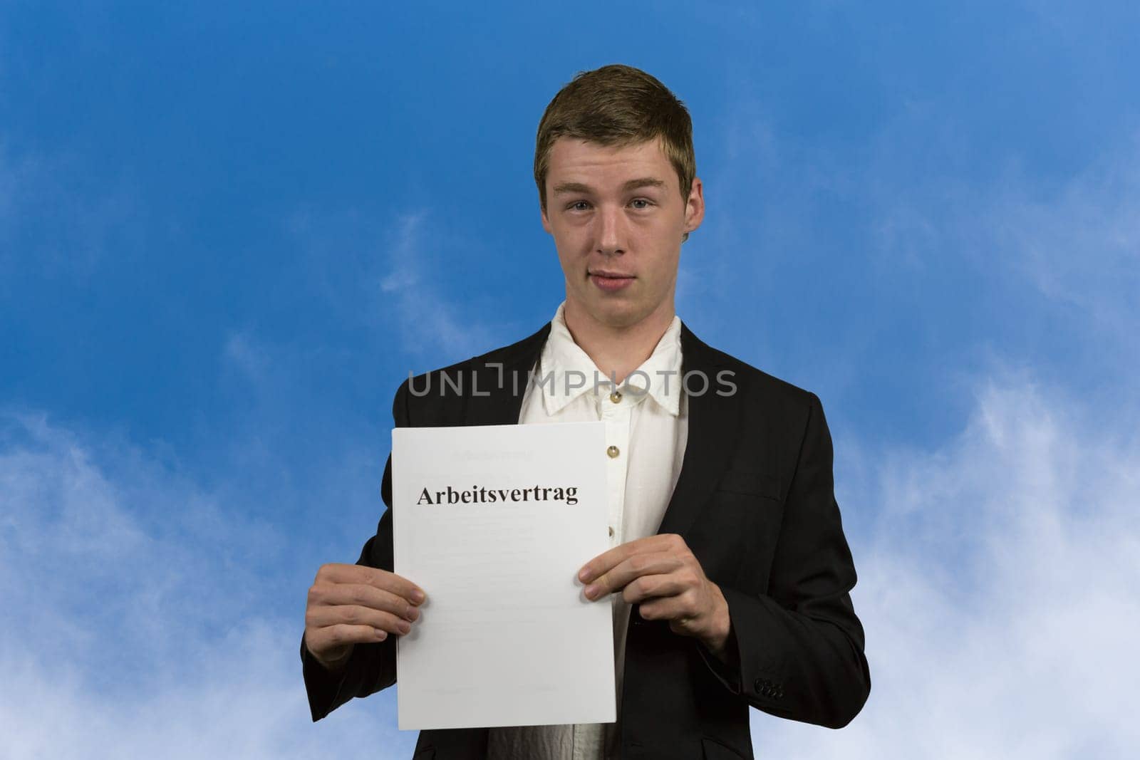 Young man holds an employment contract in his hands and is happy