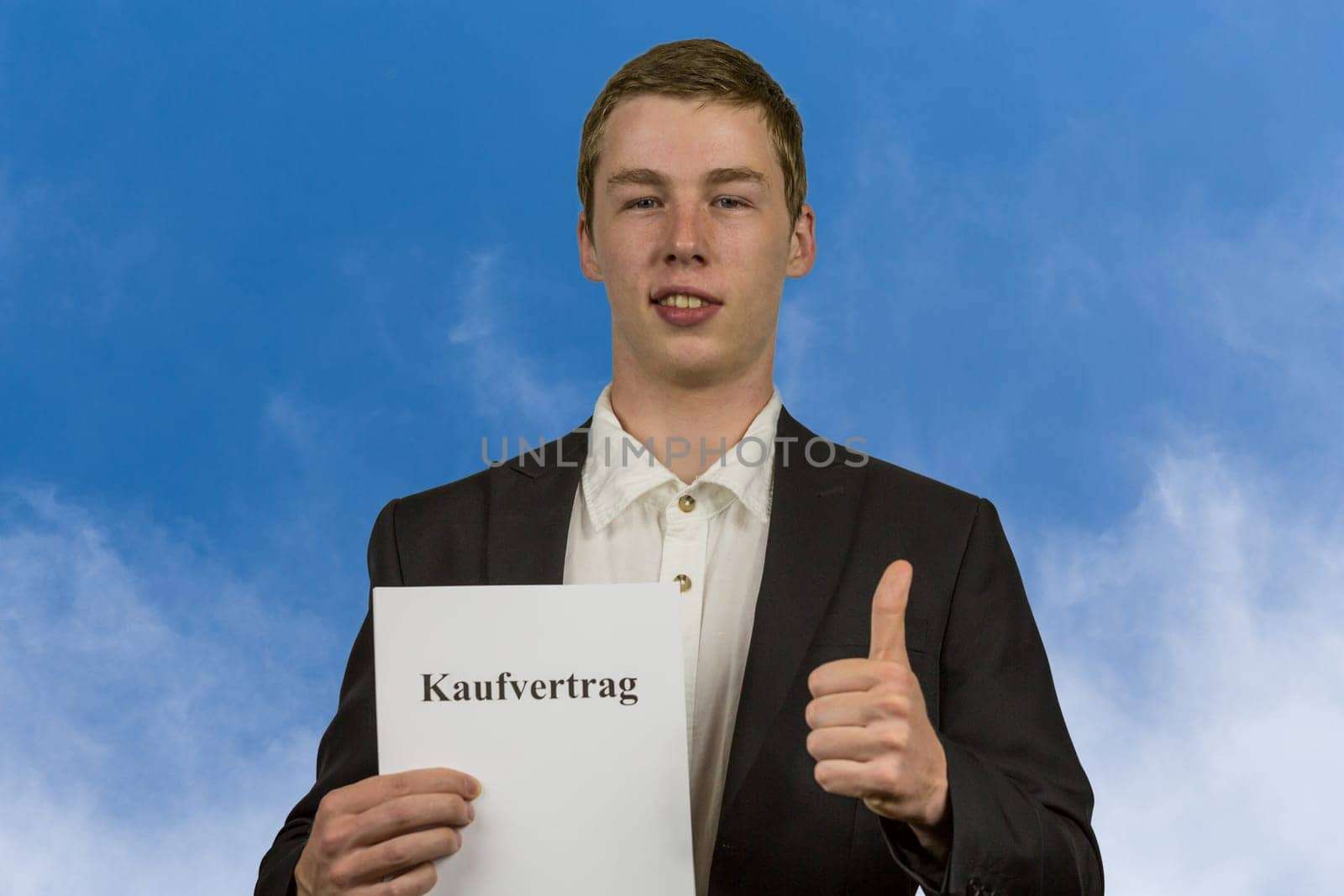 Young man holds a purchase contract in his hands and is happy