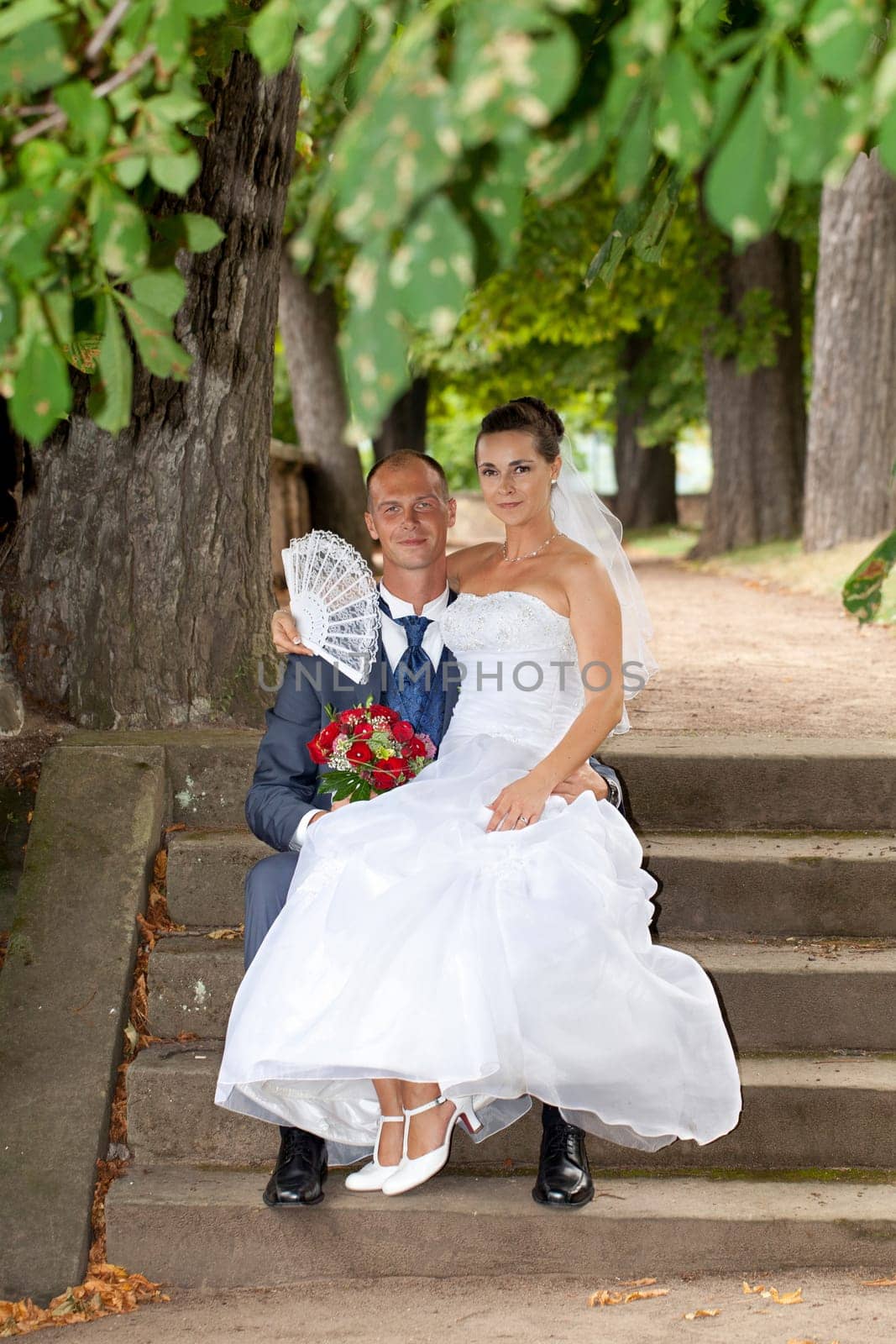 Wedding couple sitting in the castle park
