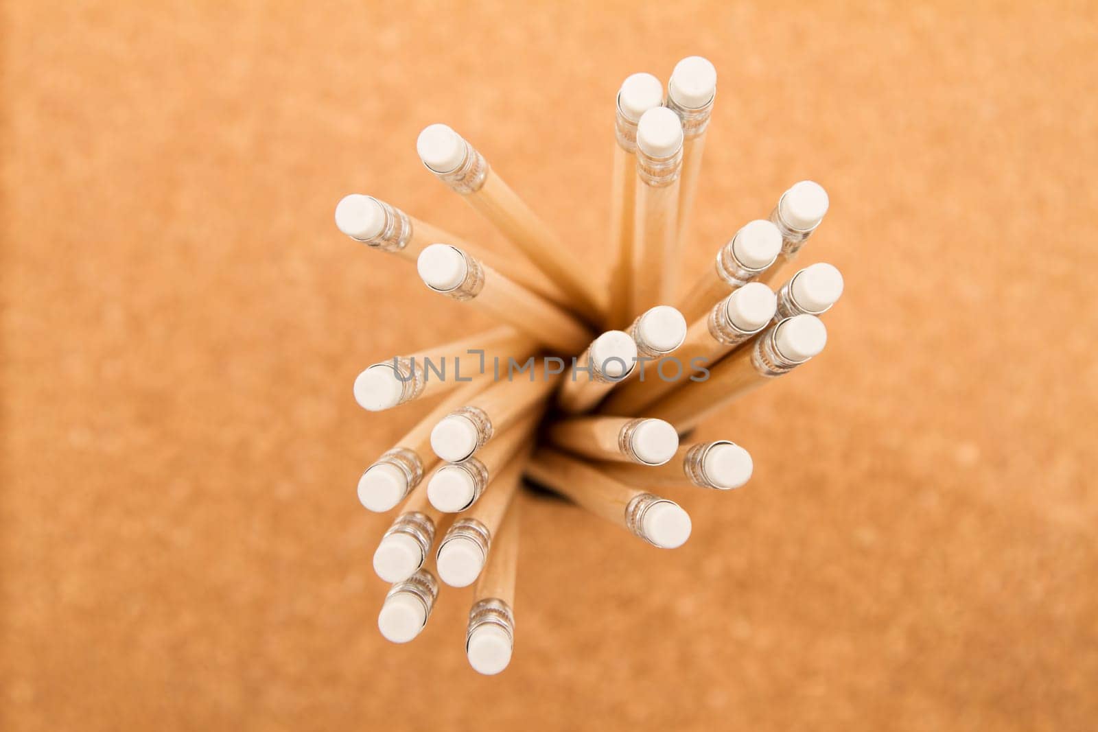 Bunch of wooden pencils over a cork board.