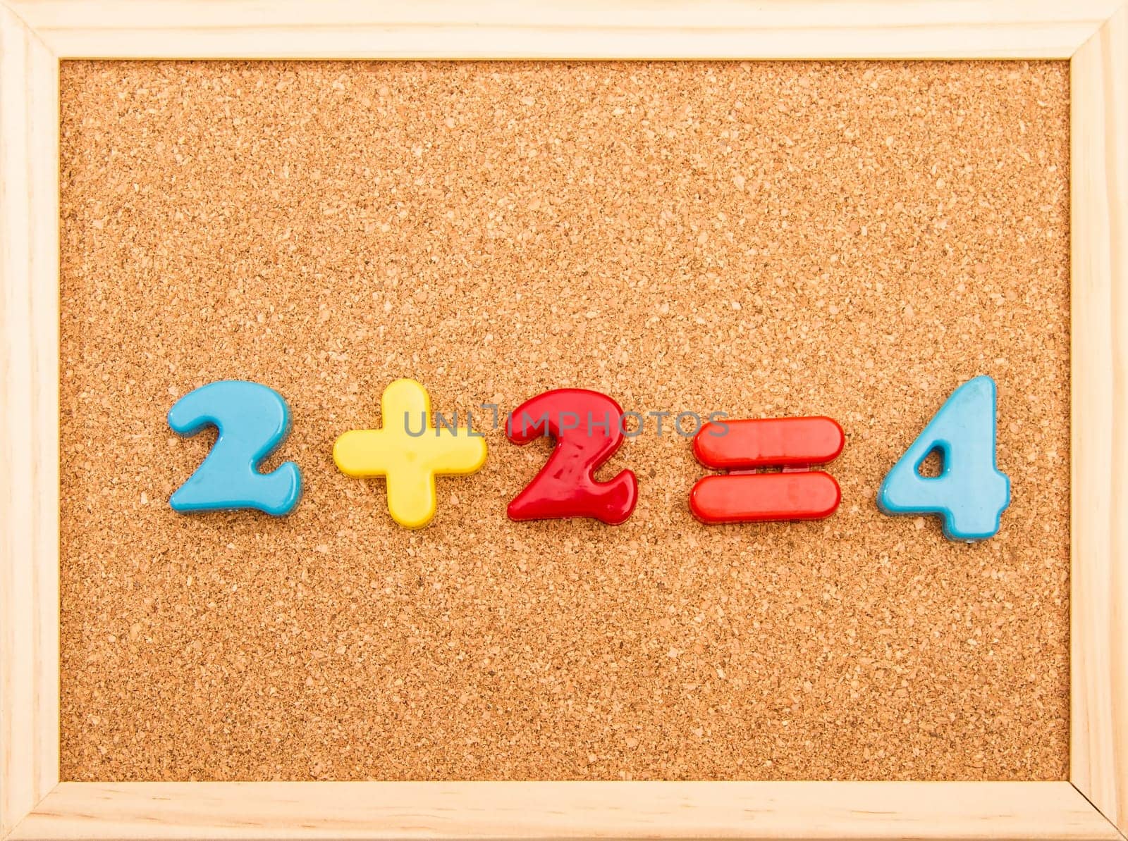 Simple mathematic addition on a wooden frame cork board.