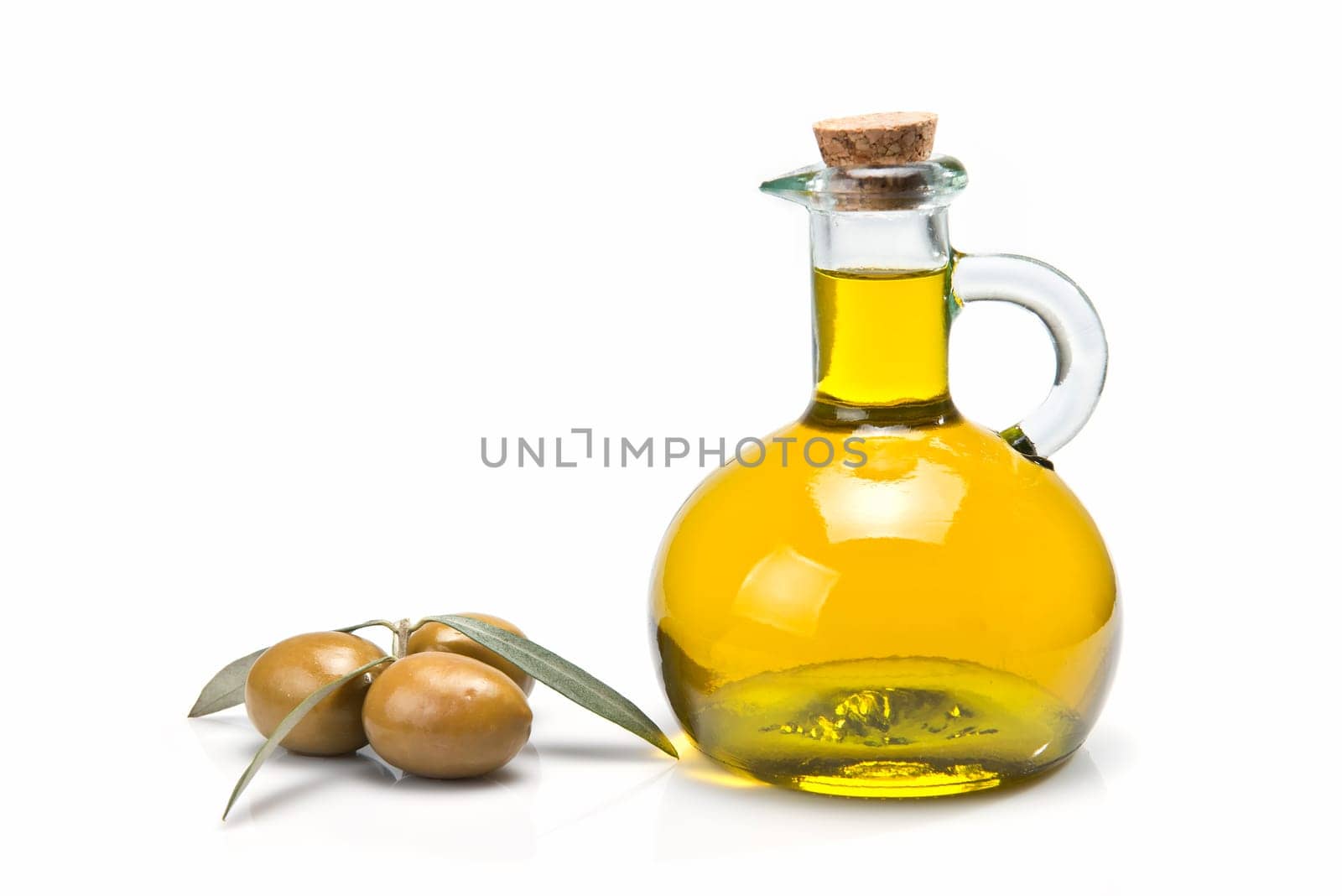 A jar with olive oil and some green olives isolated over a white background.