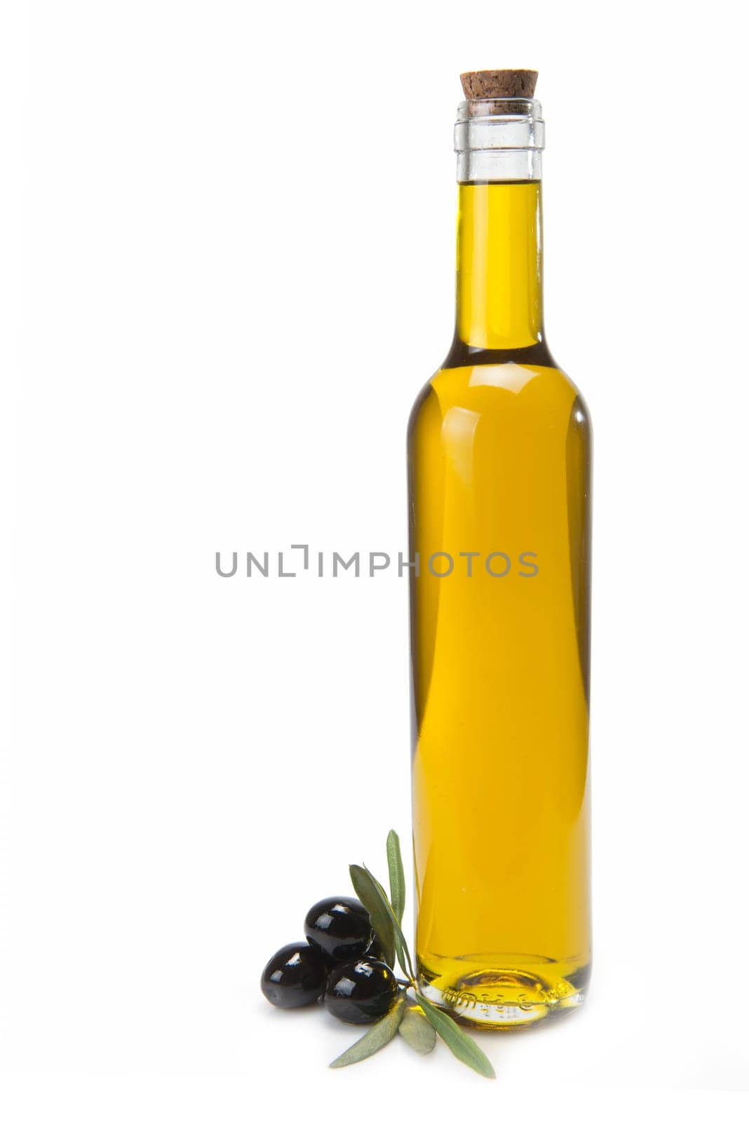 A classical glass bottle of olive oil and some black olives isolated over a white background