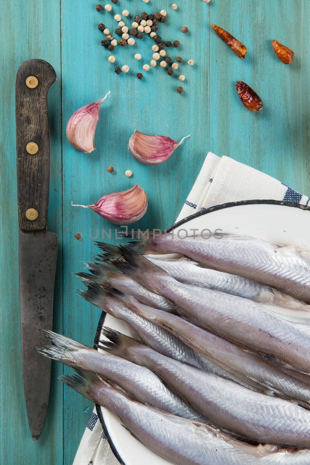 A plate with fish on the kitche table and ingredients to cook it.