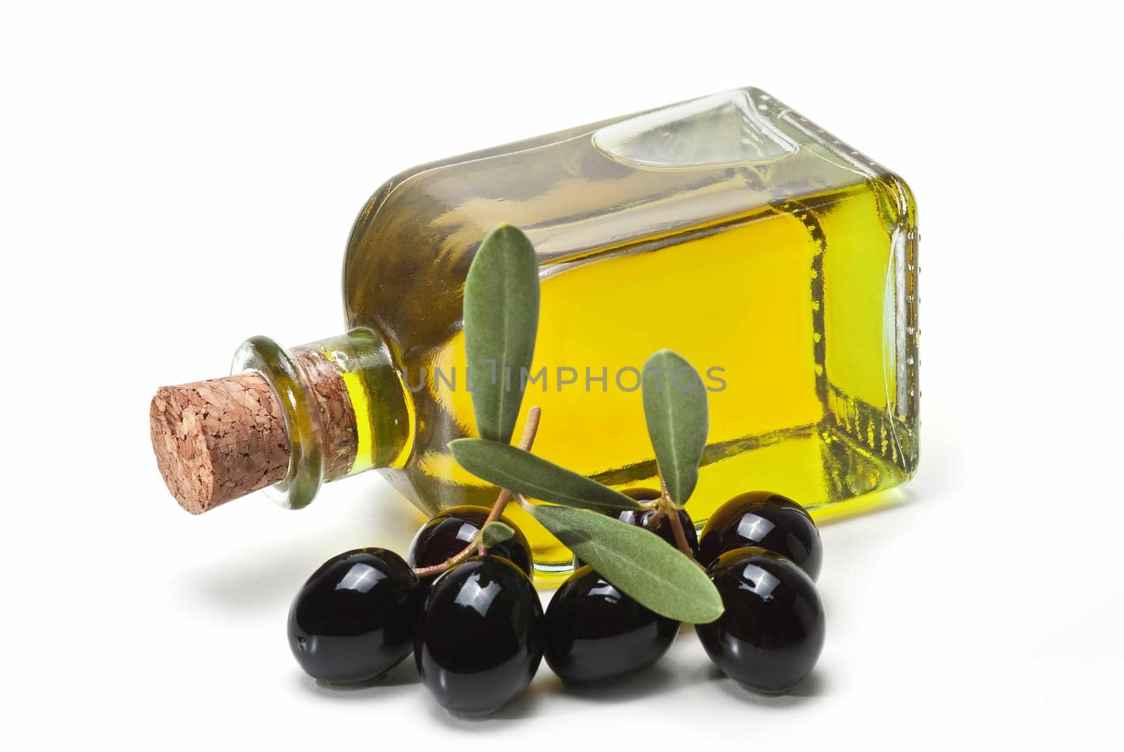 A jar with olive oil and some black olives isolated over a white background..