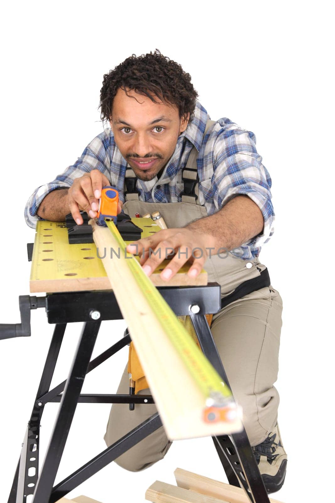 Carpenter carefully measuring plank of wood
