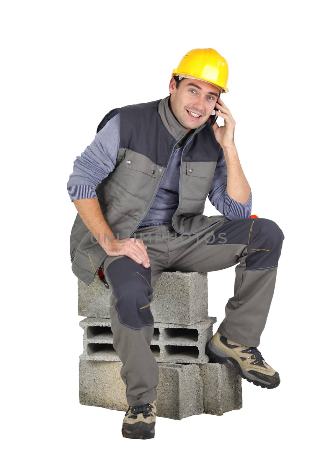 Mason speaking on the telephone whilst sat on breeze block