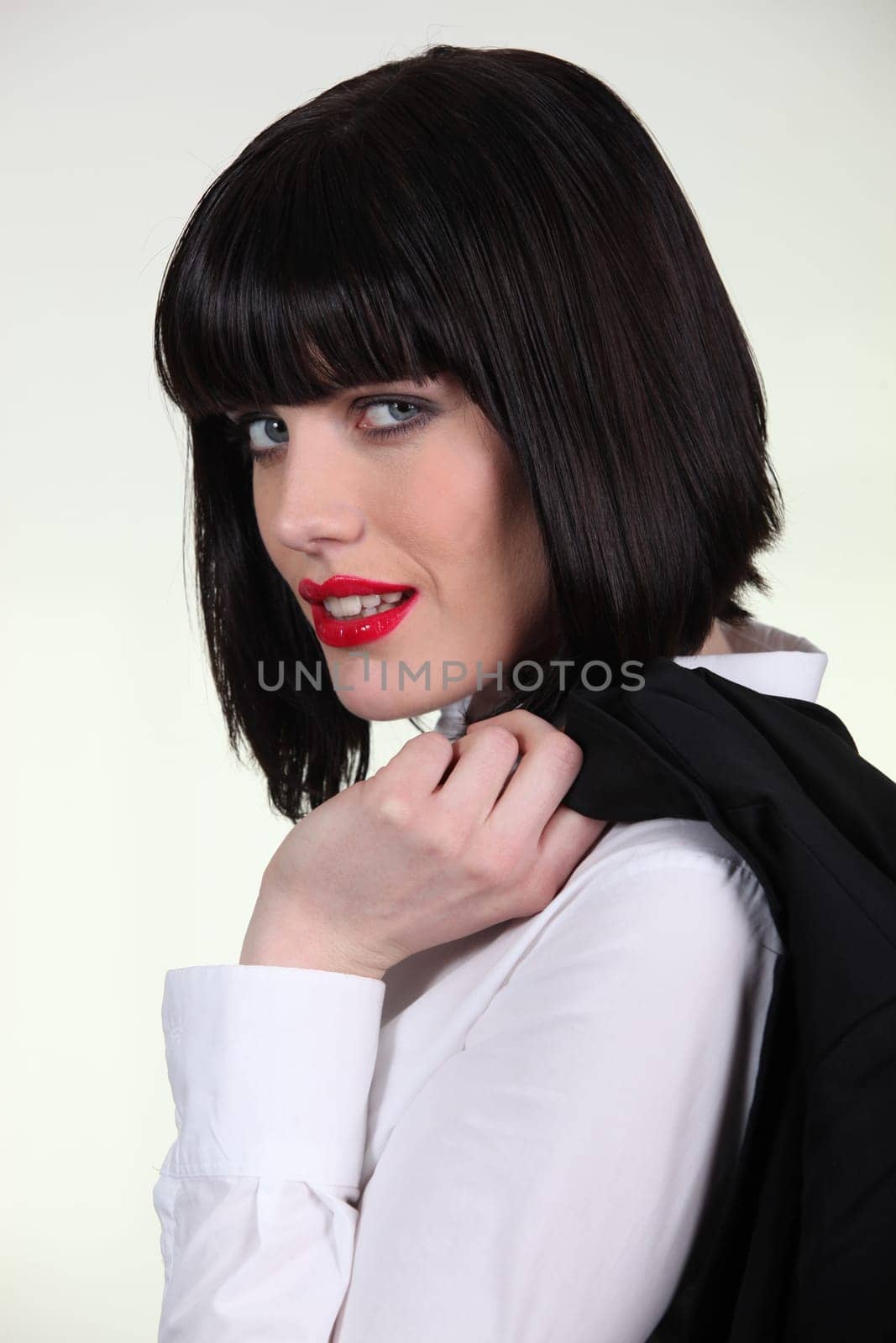 Elegant woman carrying jacket on her shoulder