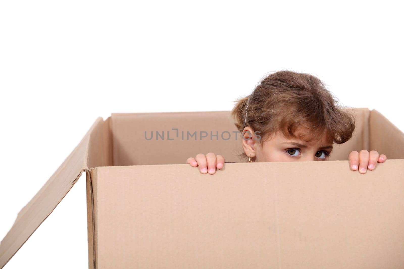 Little girl playing in a cardboard box