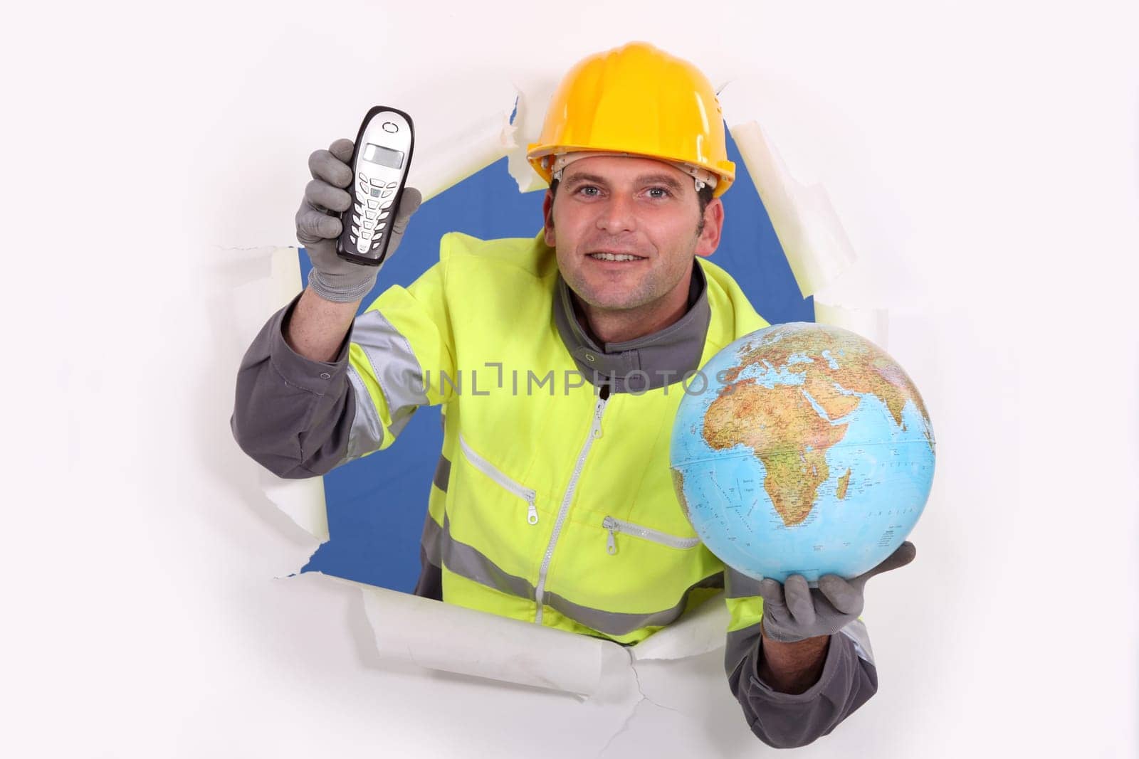 happy-looking builder holding globe and cordless phone
