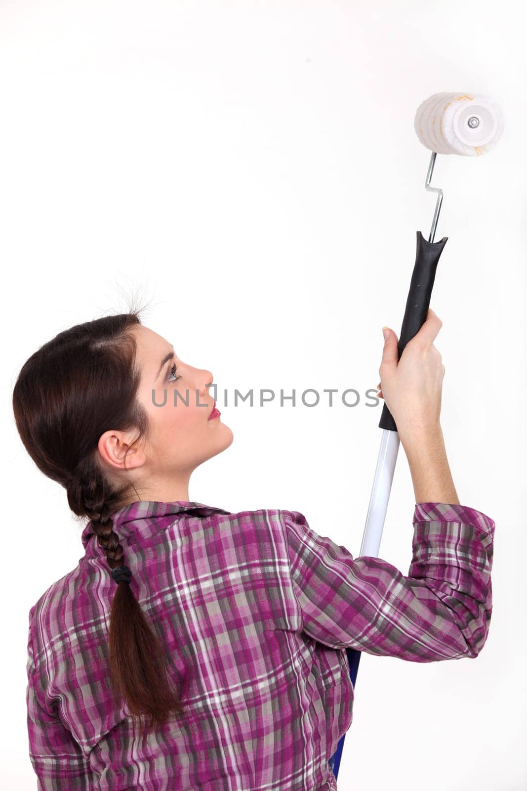 Woman using paint roller and extension