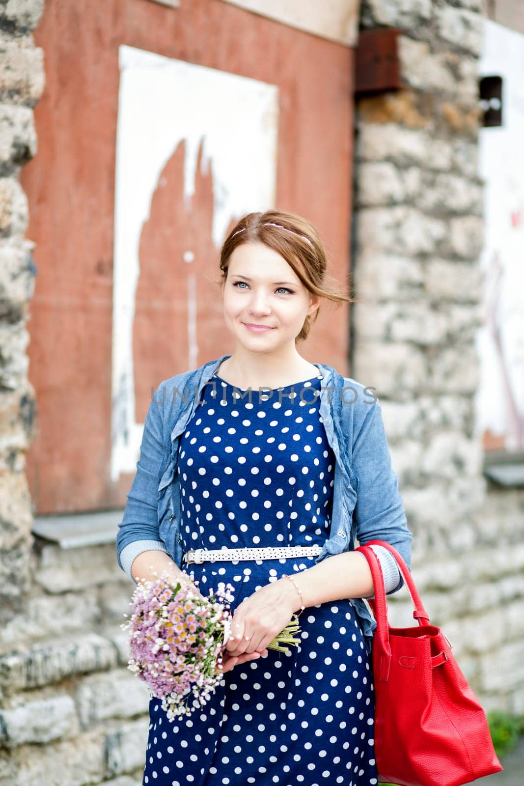 Smiling woman in dress hold bundle of flowers