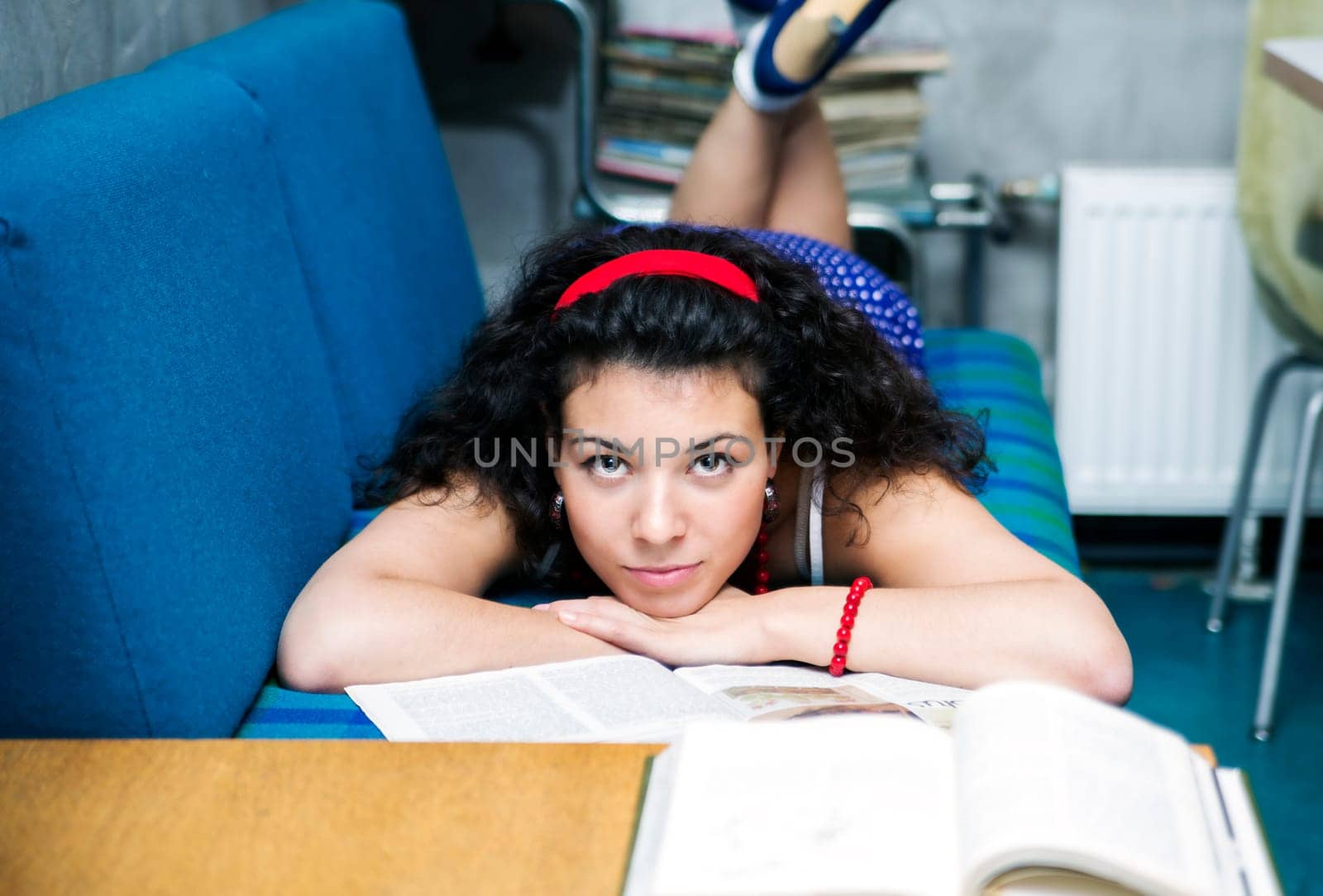 Woman lay on soft sofa and looks straight