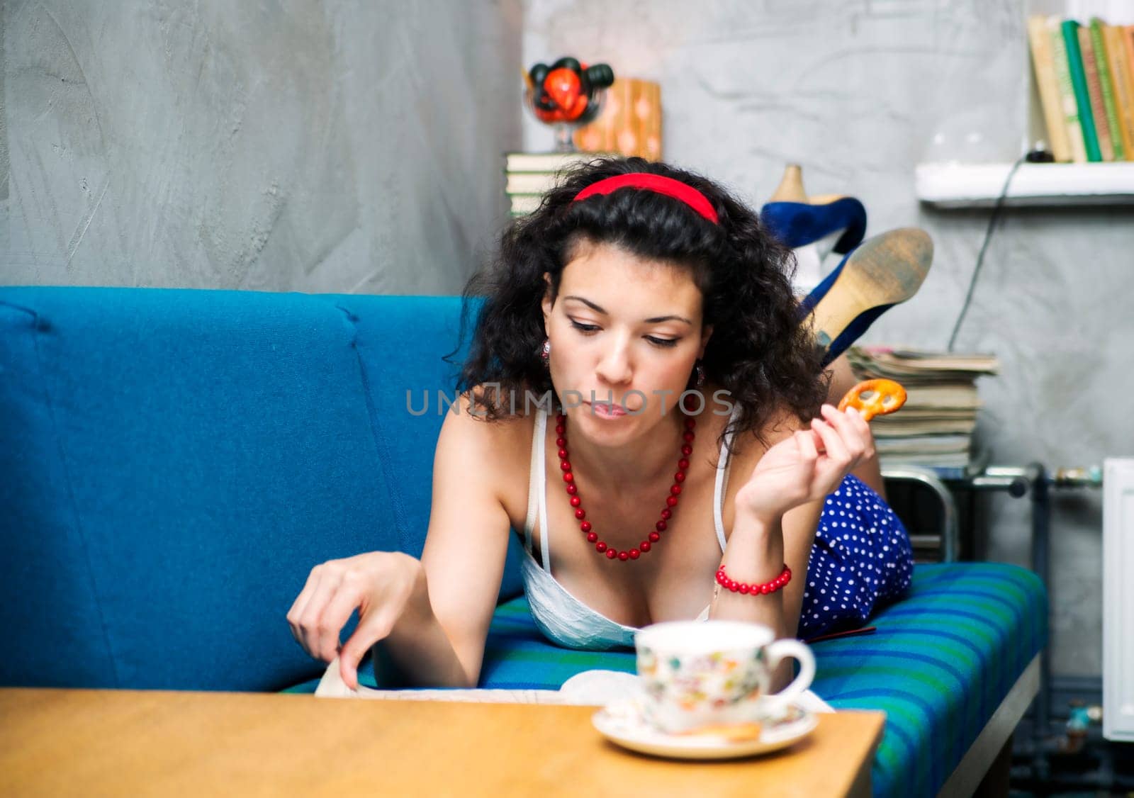 Woman lay on soft sofa and read magazine