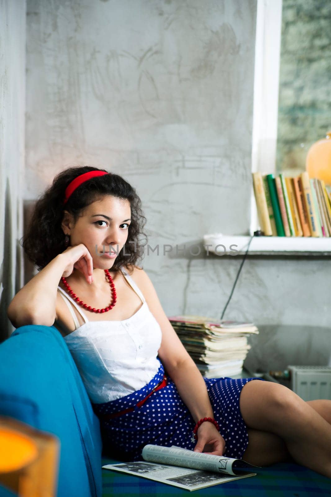Woman rest on soft sofa and browsing magazine