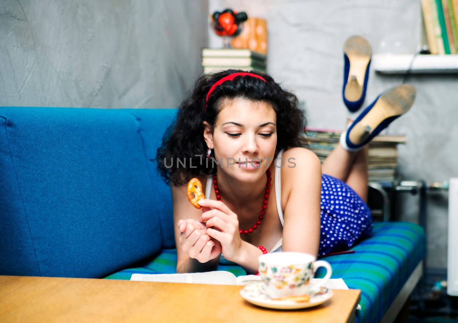 Woman lay on sofa and read funny book