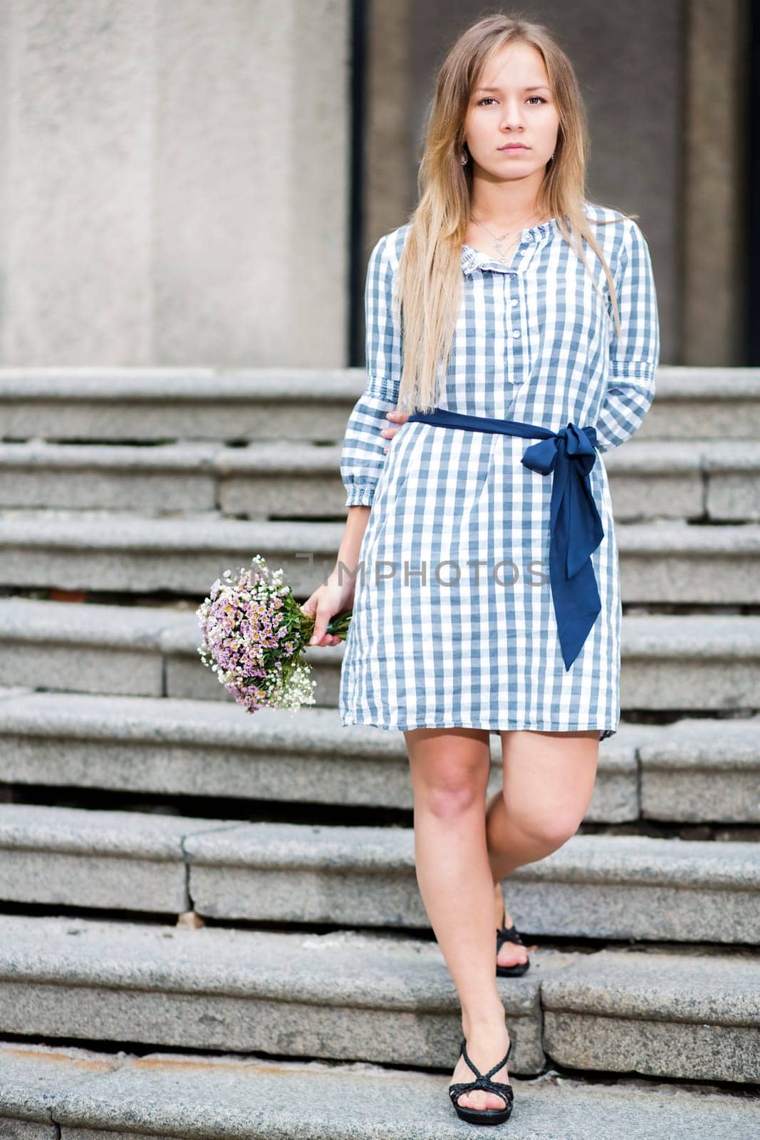 Woman in checkered dress at main enter stairs