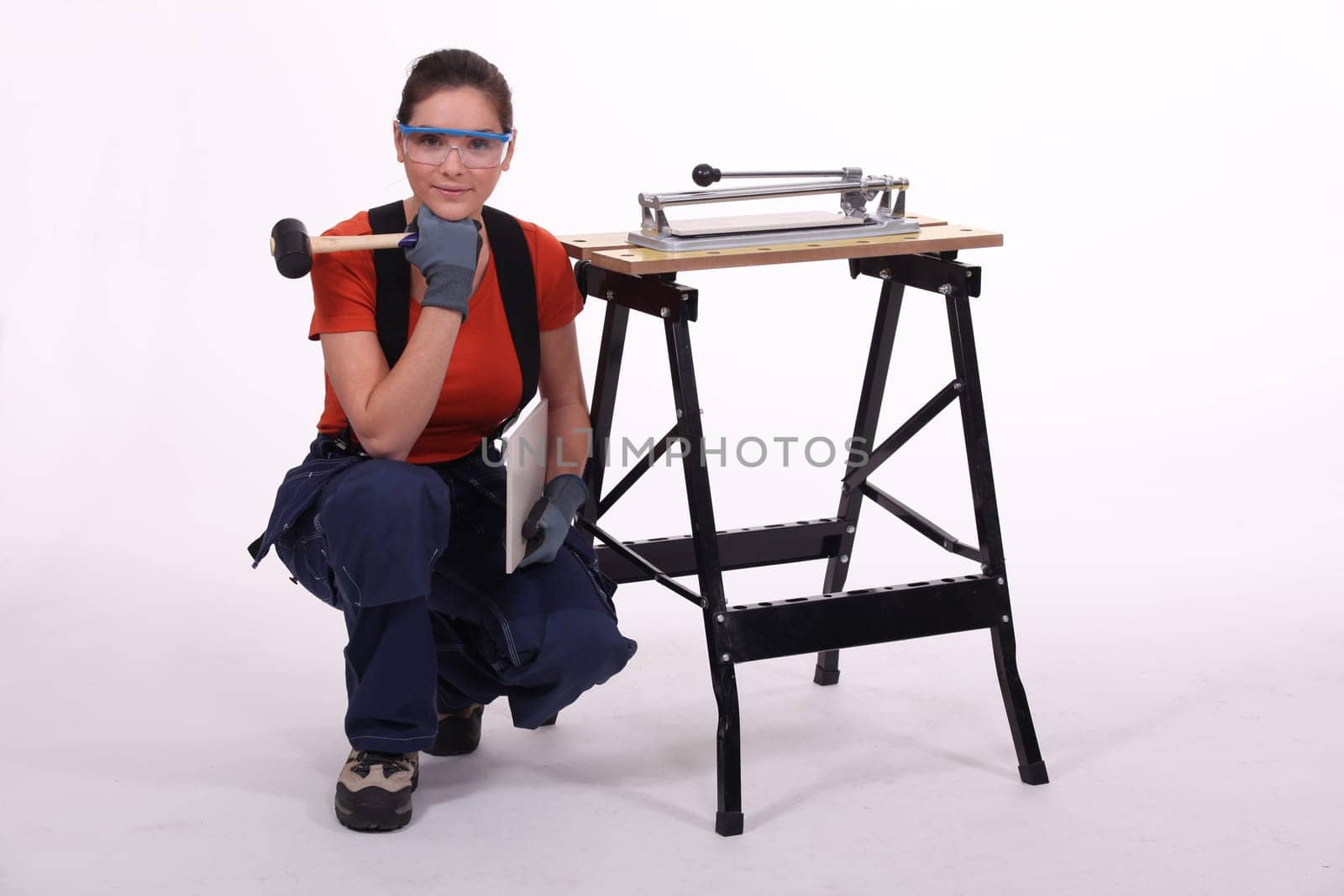 Woman kneeling beside her workbench