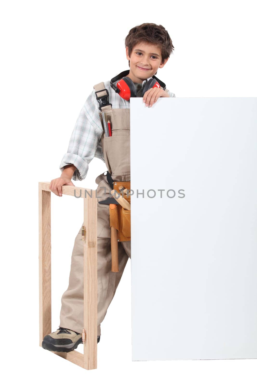 Young boy dressed as a carpenter with a board left blank for your message