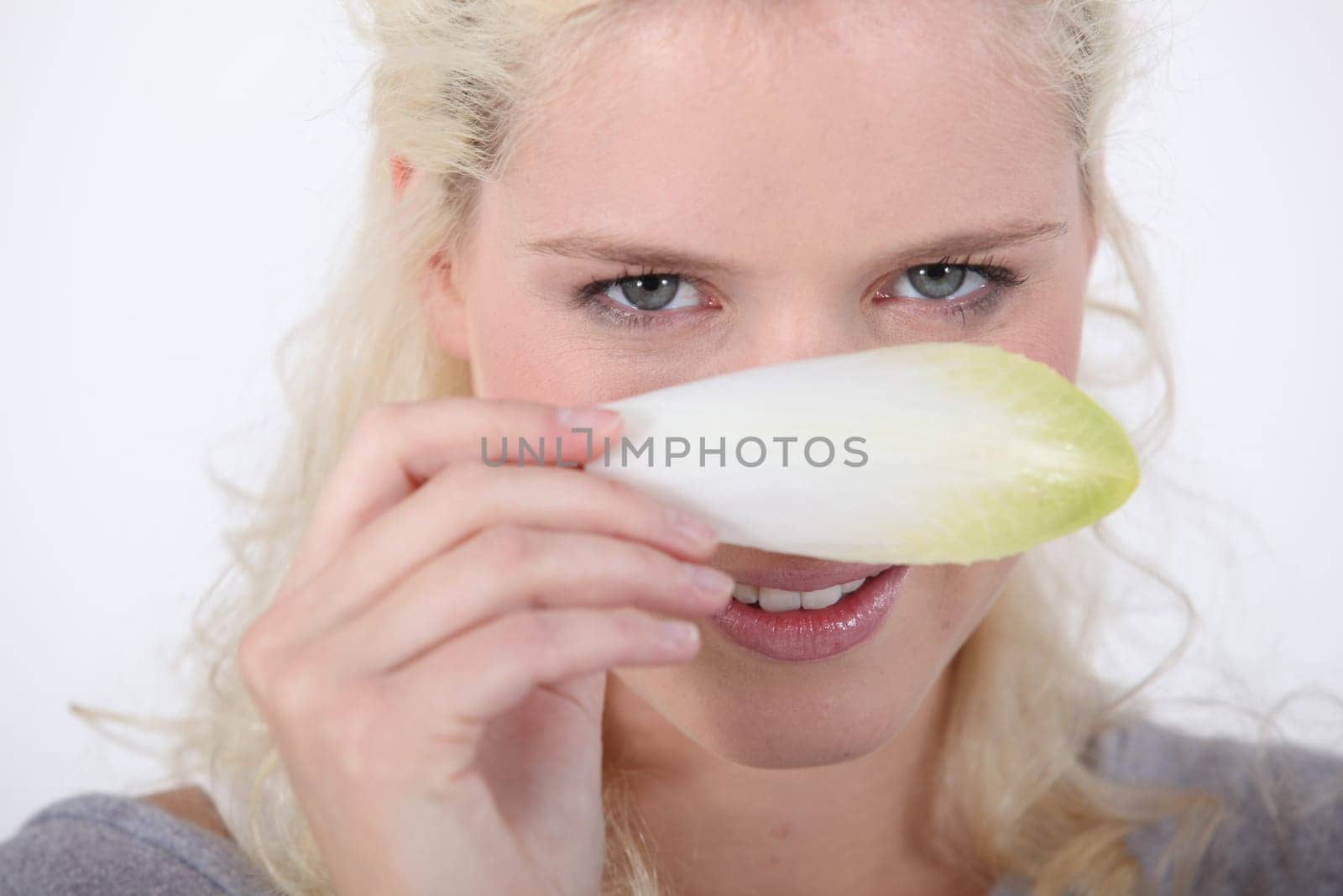 Woman hiding behind an endive leaf