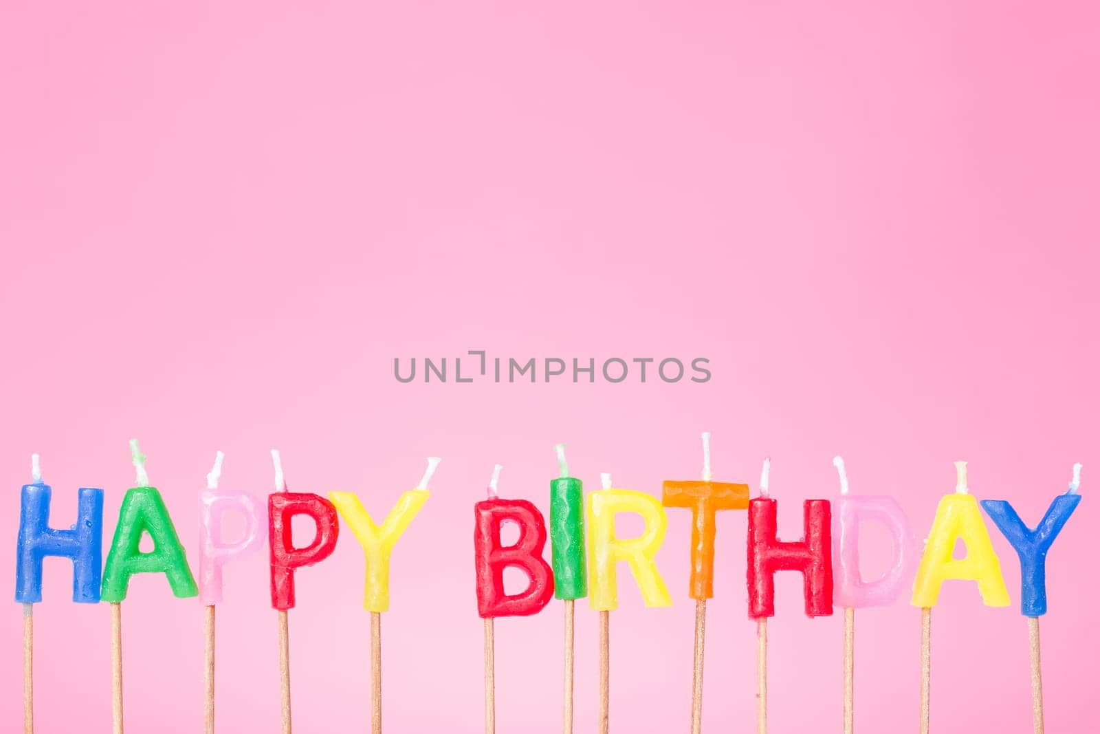 Colorful  Happy birthday candles on the  pink background