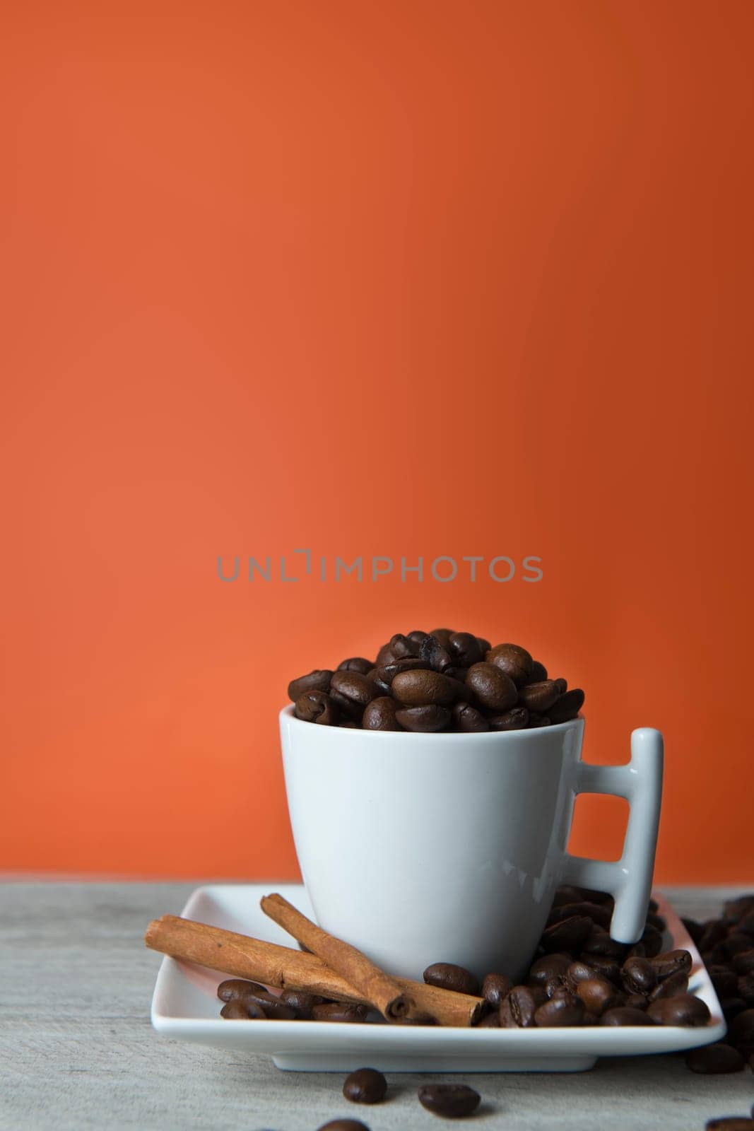 Cup of coffee and beans on an orange vintage background.