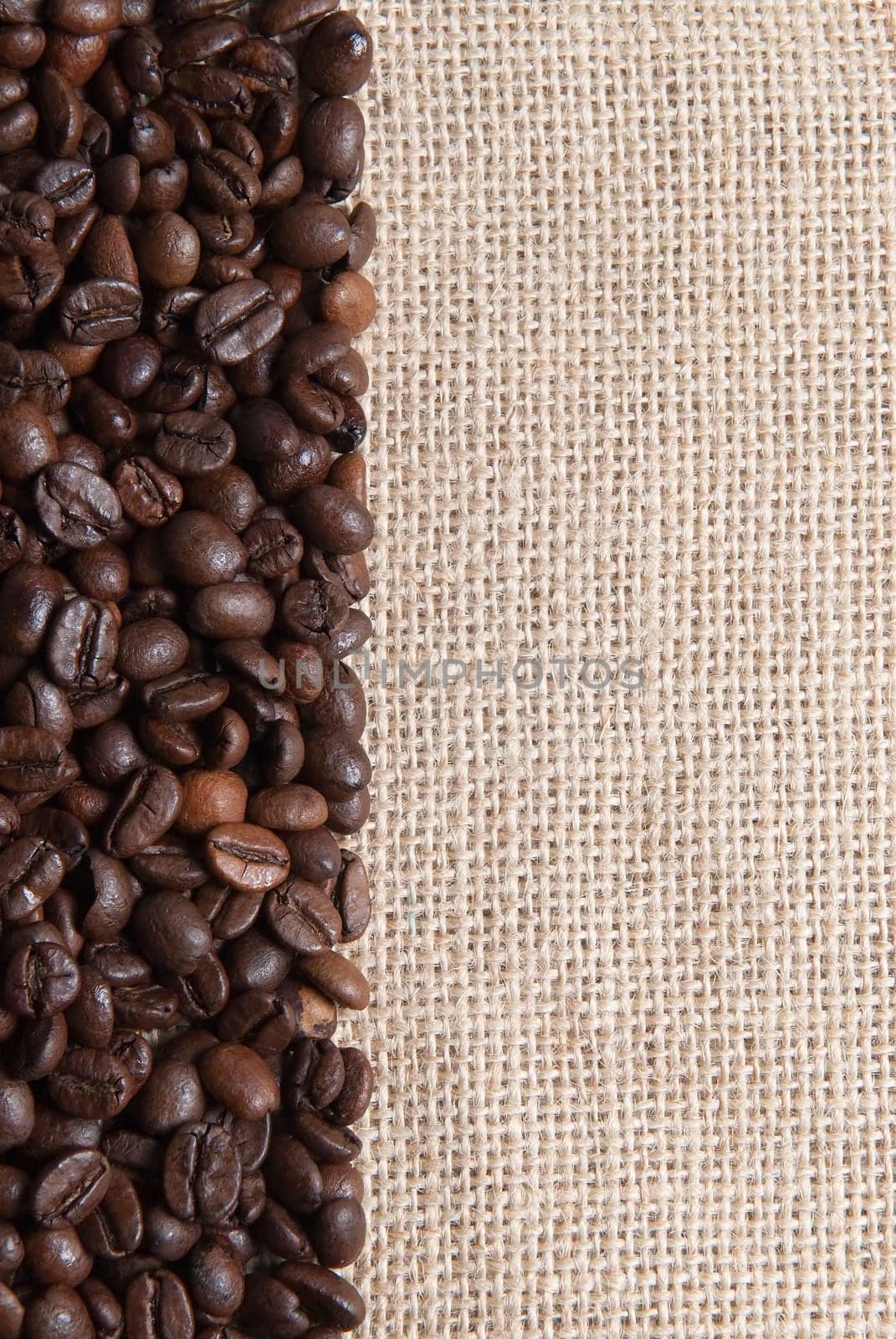 Background of burlap and coffee beans with a copy space.