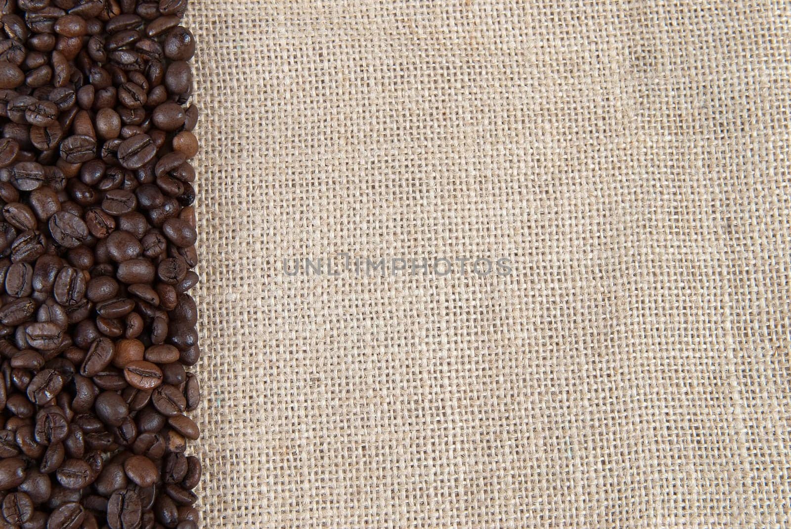Background of burlap and coffee beans with a copy space.