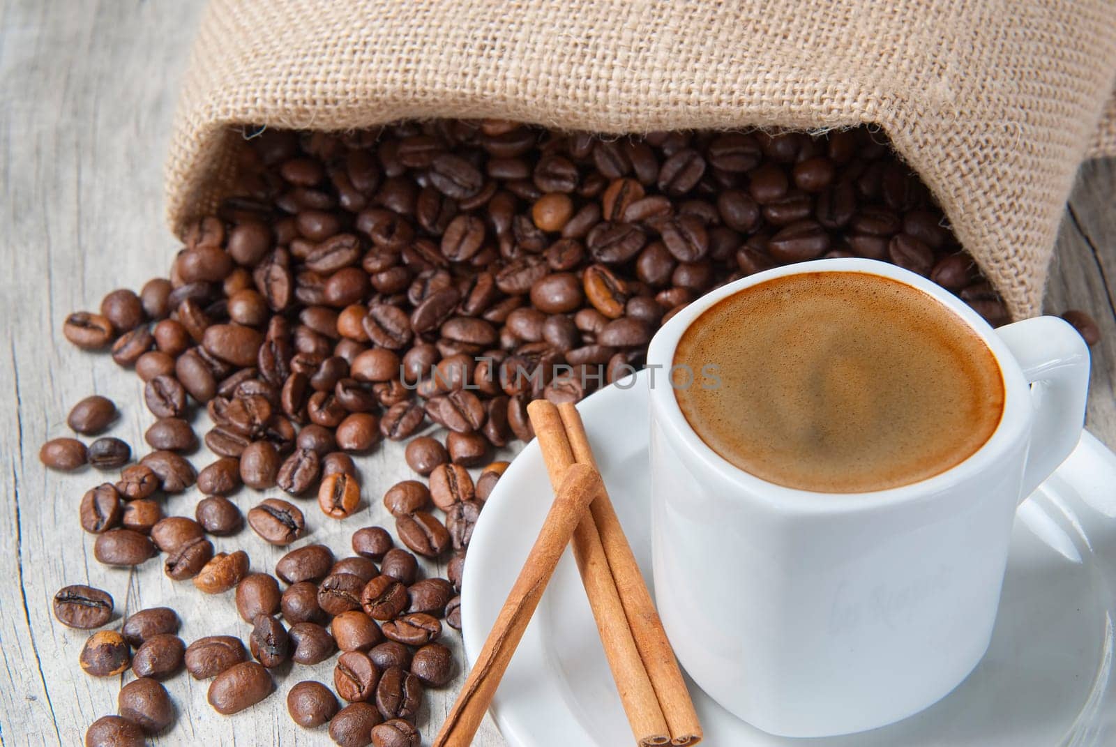 Still life about coffee with a delicious  espresso and some coffee beans and cinnamon.
