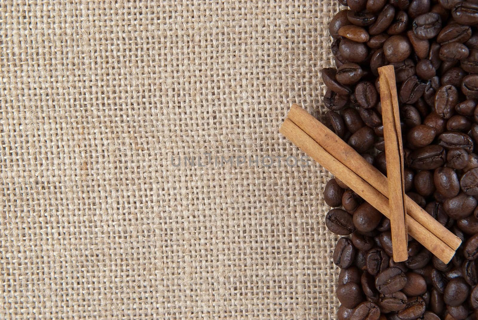 Background of burlap and coffee beans with a copy space.