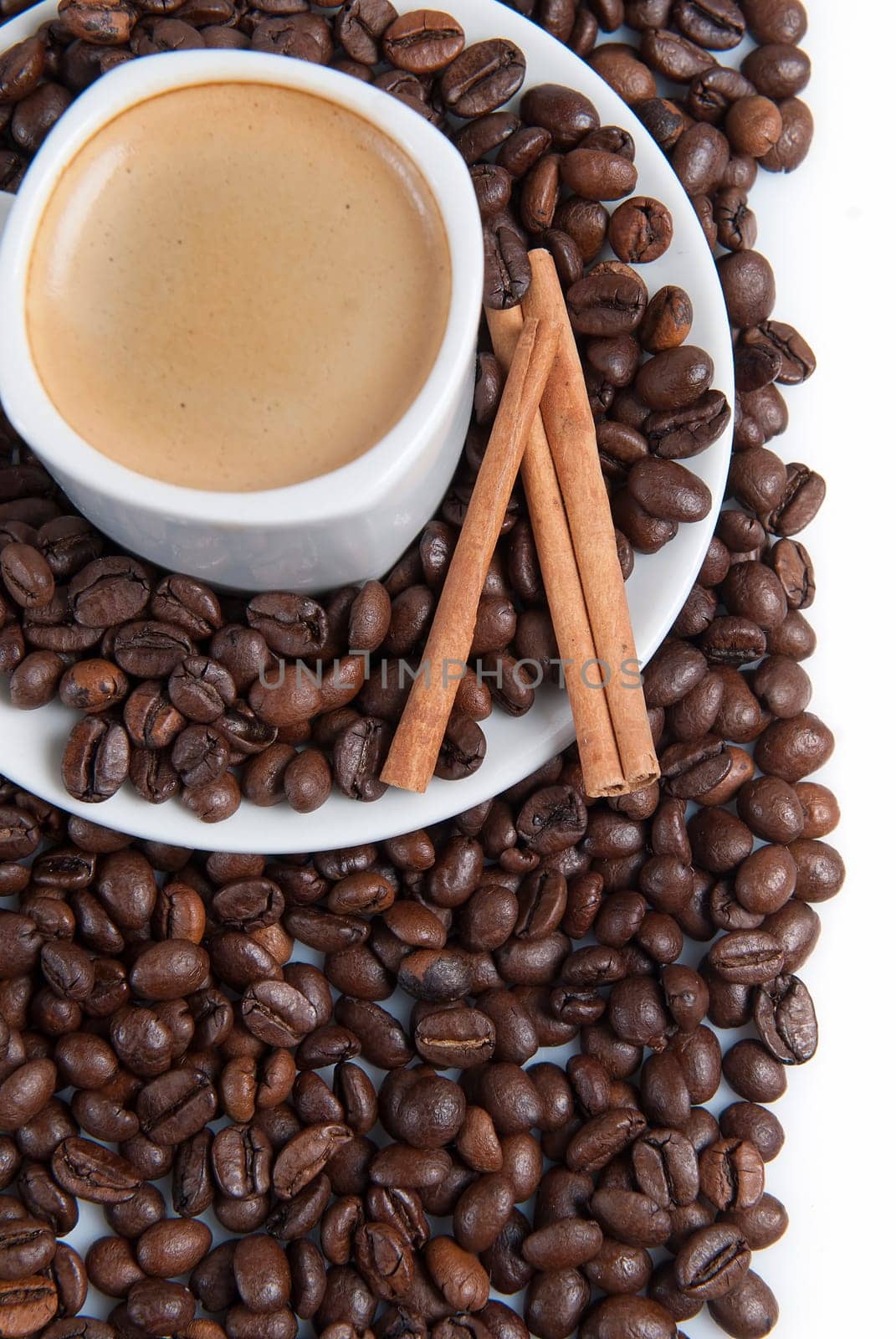 Still life about coffee with a delicious  espresso and some coffee beans and cinnamon.