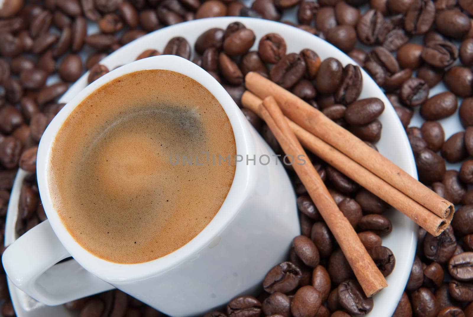 Still life about coffee with a delicious  espresso and some coffee beans and cinnamon.