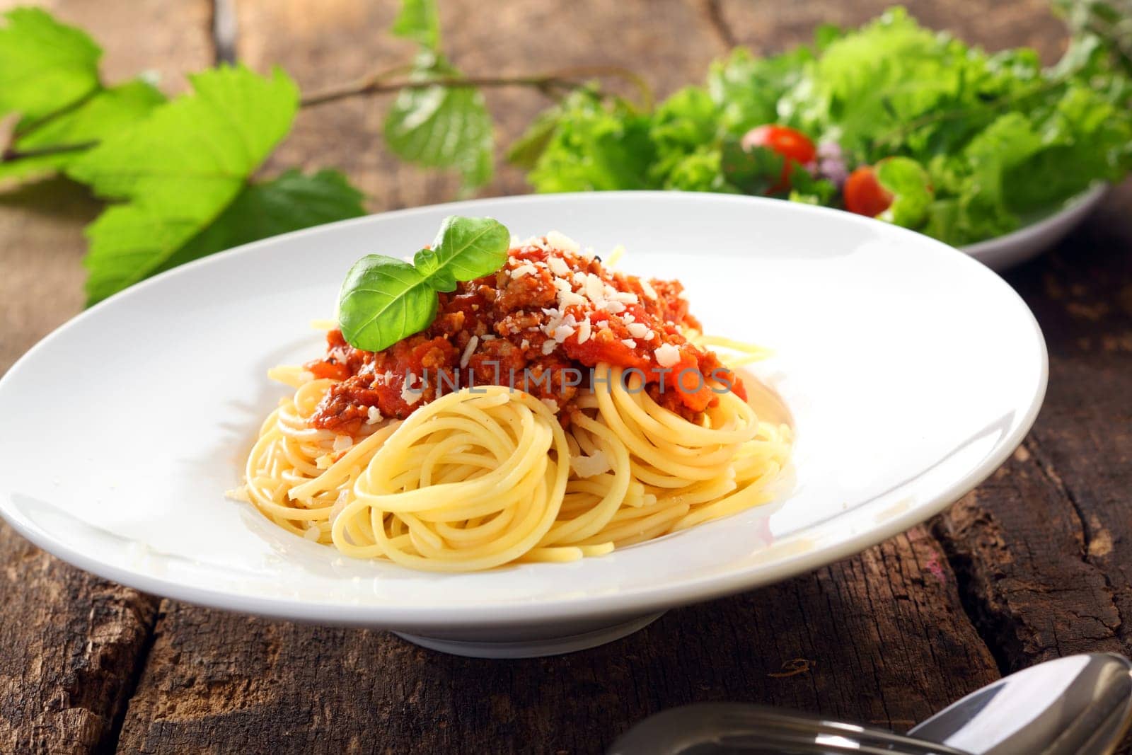Italian pasta with carefully twirled spaghetti topped with a meat and tomato based bolognese, or bolognaise, sauce