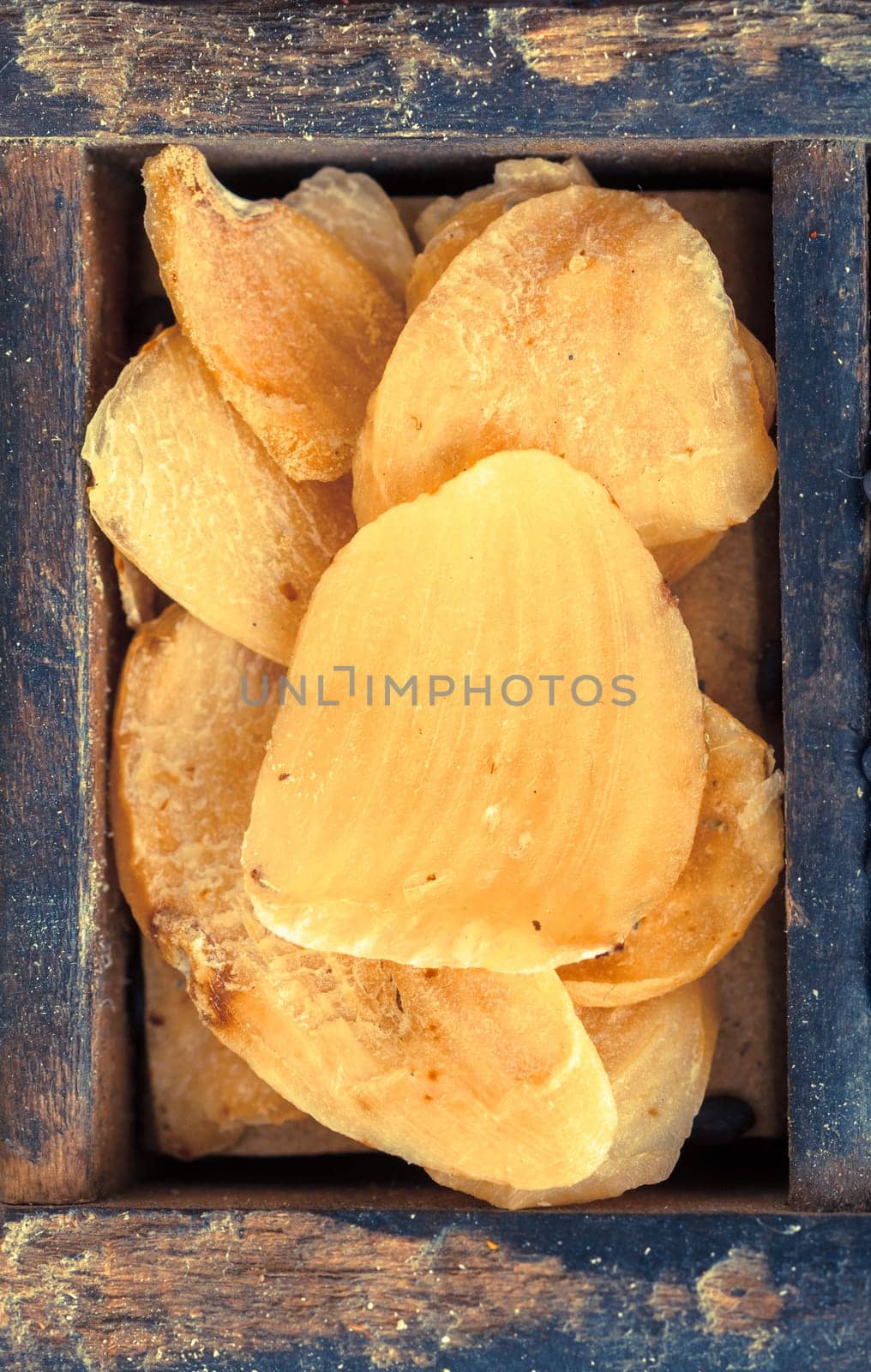 Dried flakes of grated garlic for use as a seasoning and flavouring in cooking, close up view showing the texture