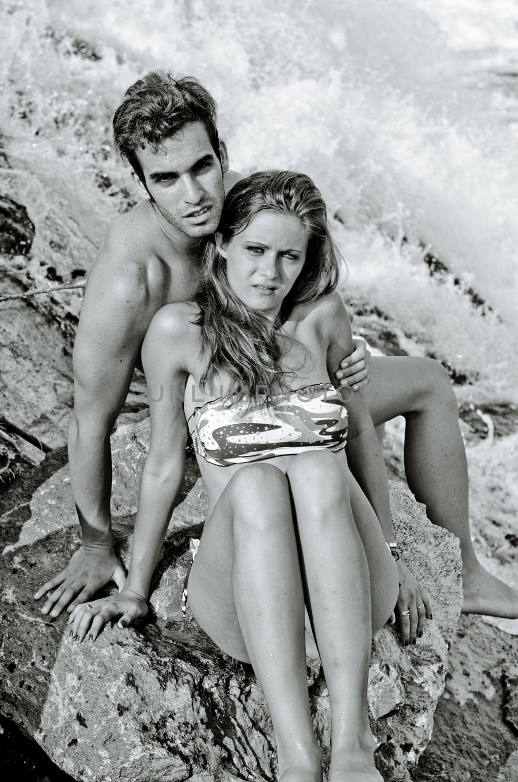 Romantic couple next to river waterfall, naked, wearing swimming suit and bikini