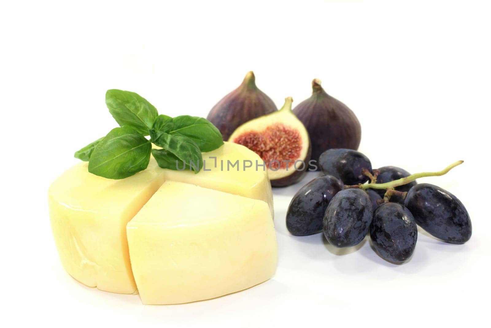 a piece of cheese with cheese knife and basil