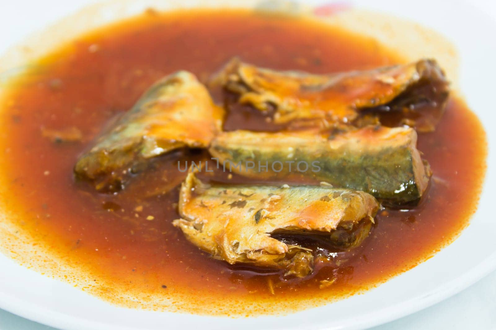 Canned fish in tomato sauce on dish